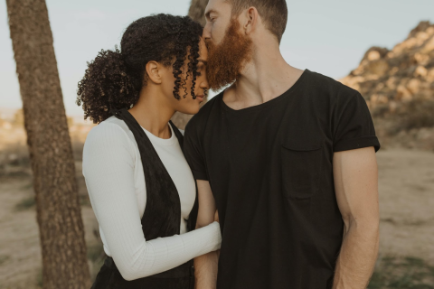Man kissing a woman's forehead