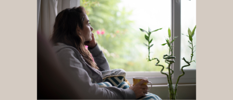 Woman staring out the window looking sad