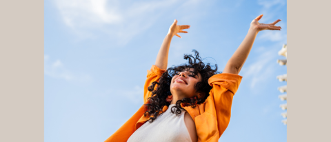 Woman celebrating against a blue sky